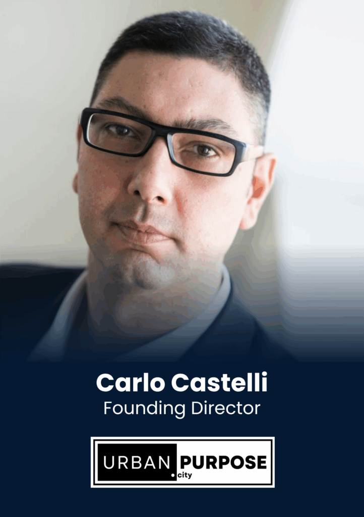Portrait of Carlo Castelli, Founding Director, wearing glasses and a dark blazer, with a navy background and Urban Purpose City logo below.
