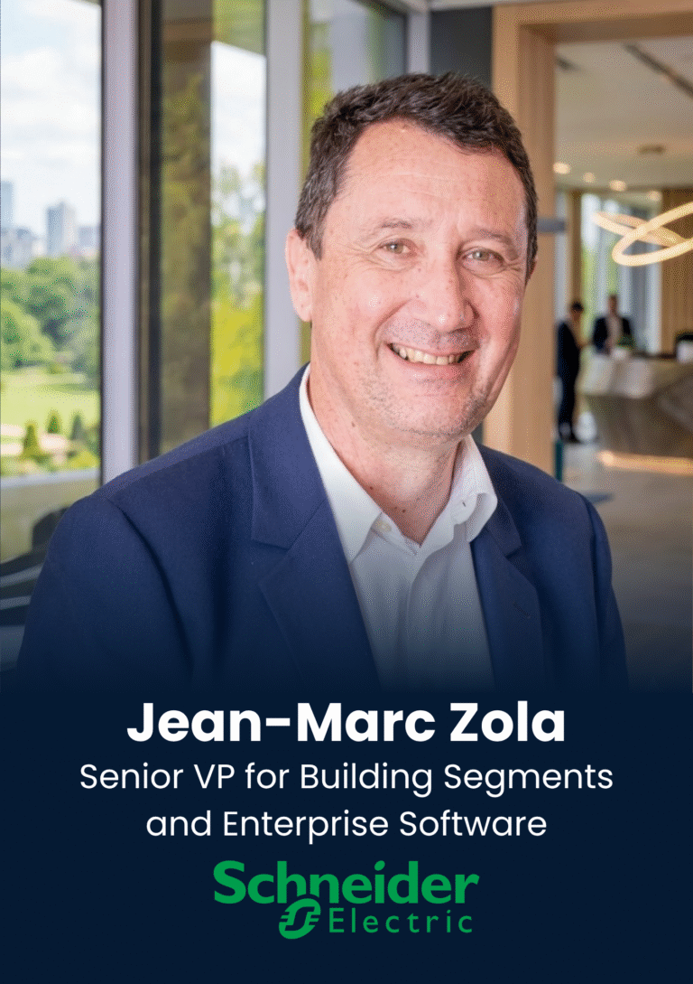 Head-and-shoulders corporate portrait of Jean-Marc Zola in a navy suit, smiling in a modern office environment with a Schneider Electric banner below.
