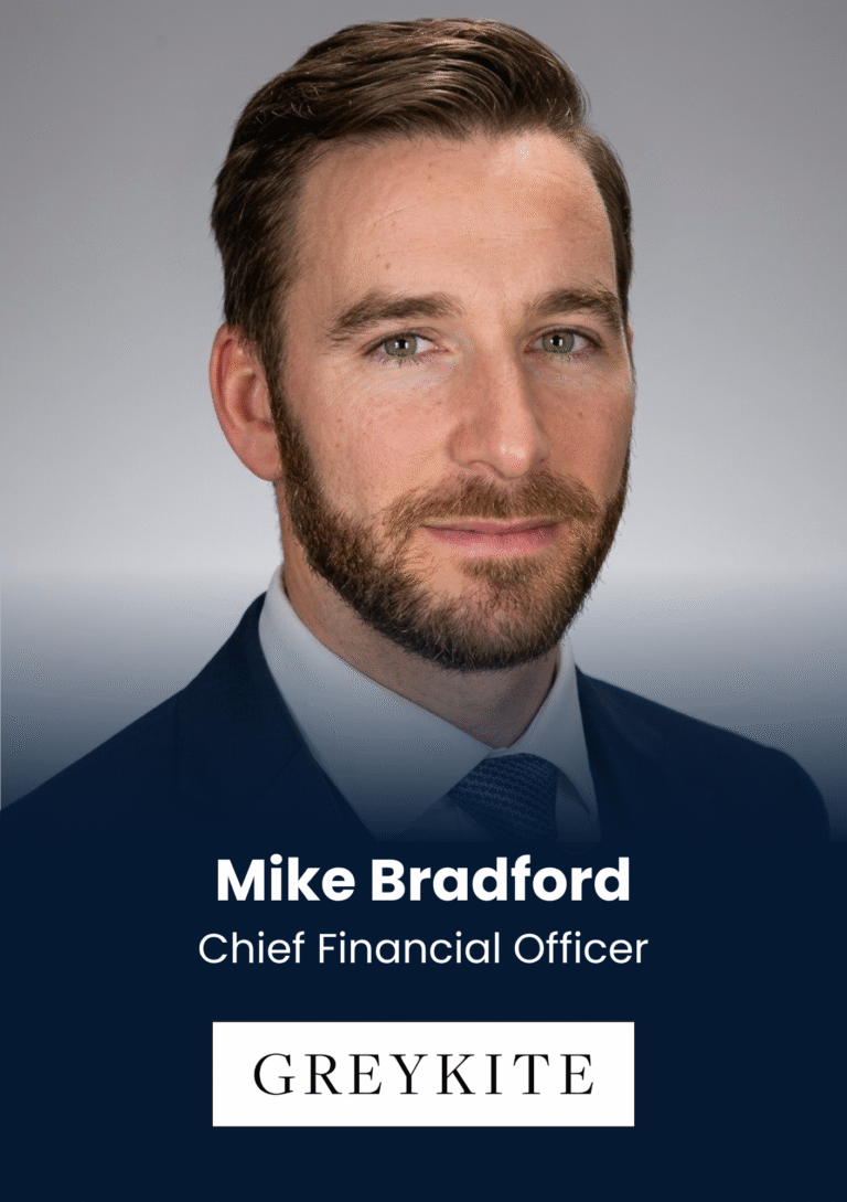 Portrait of Mike Bradford, Chief Financial Officer, in a navy suit with GREYKITE branding on a dark blue banner.