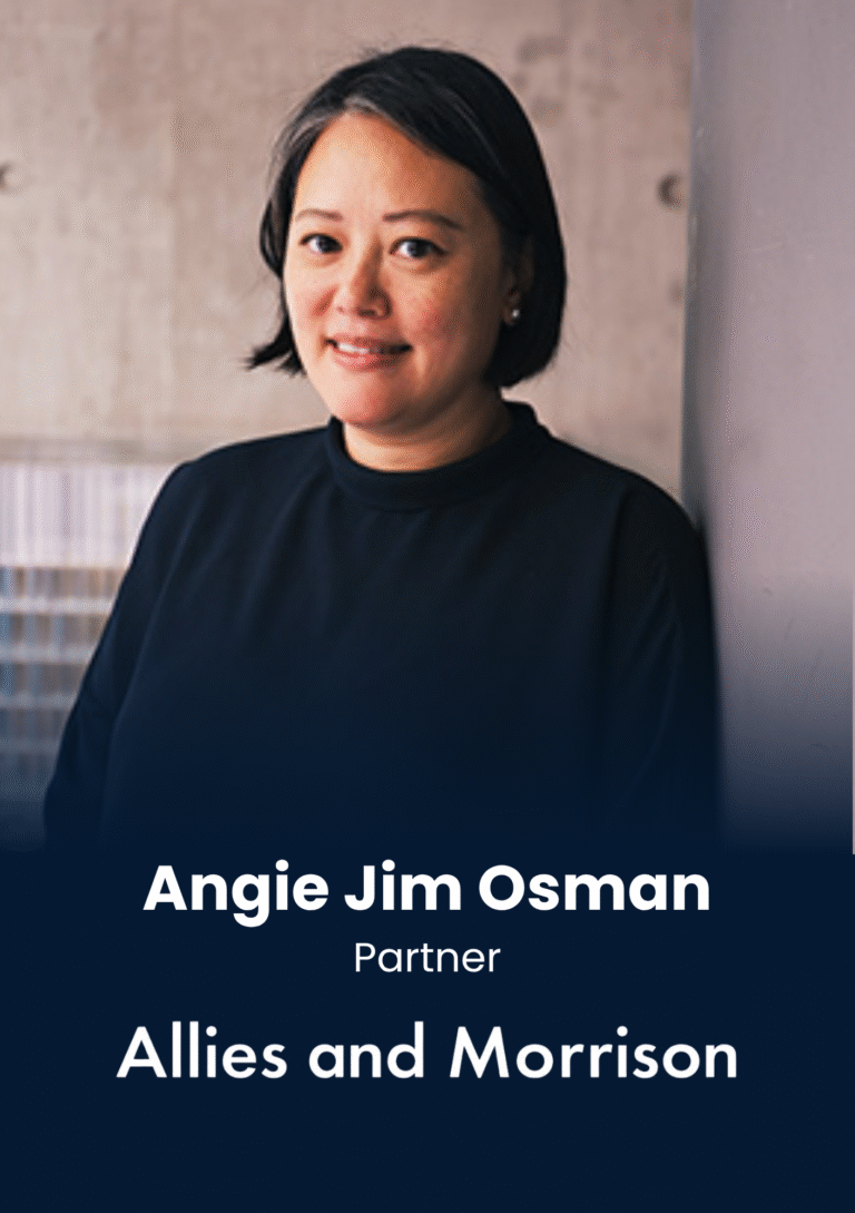 Portrait of Angie Jim Osman, Partner at Allies and Morrison, standing against a wall in a navy top.
