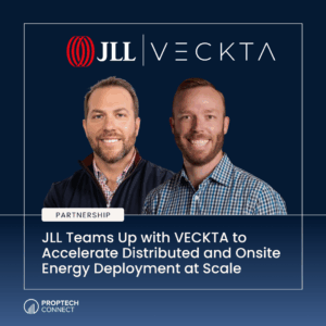 Two men smiling in front of a navy banner with JLL | VECKTA logos and a 'PARTNERSHIP' badge; headline mentions accelerating energy deployment at scale.