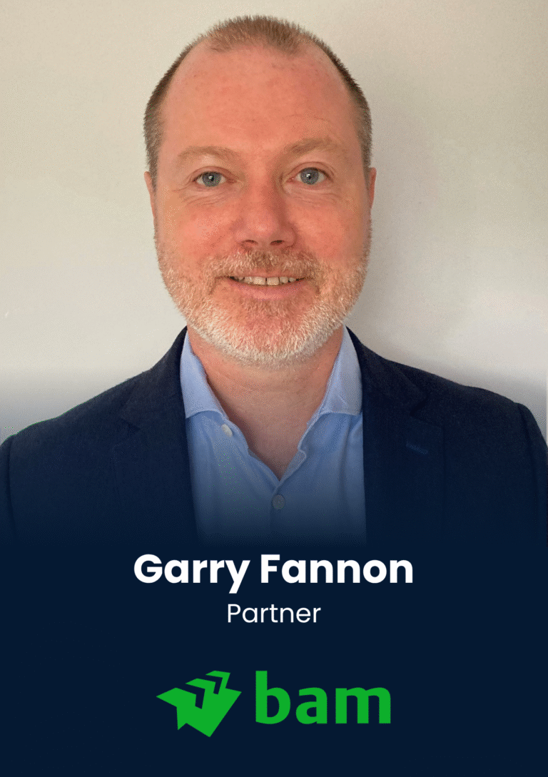 Portrait of a smiling man in a blue shirt and dark blazer, with the name Garry Fannon and title Partner over a dark background at the bottom. Reusable as a professional headshot with branding text visible.