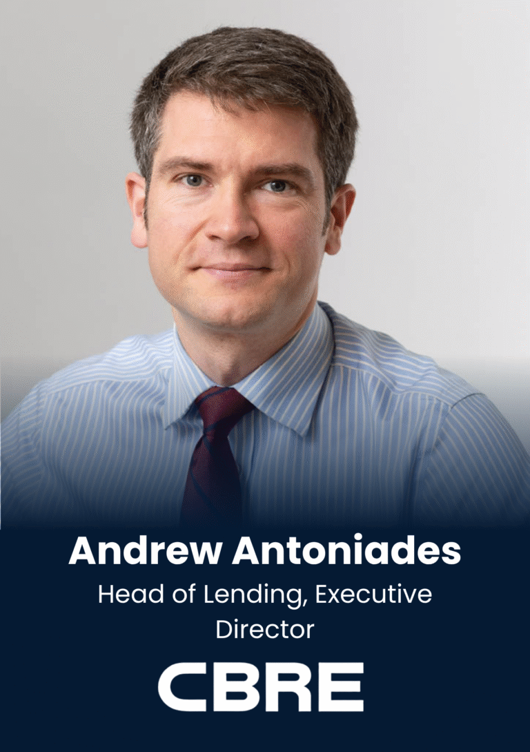 Portrait of Andrew Antoniades, smiling man in a striped blue shirt and burgundy tie, used as a professional headshot for CBRE materials.