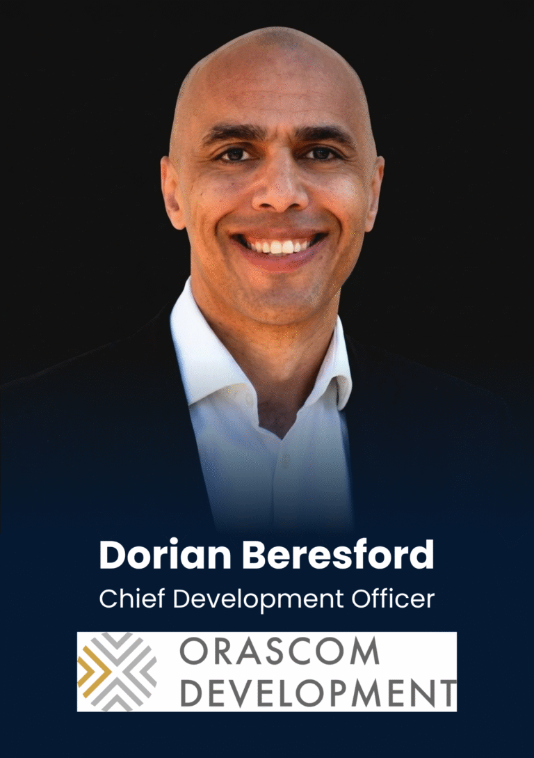 Portrait of Dorian Beresford, Chief Development Officer, smiling in a suit against a dark background.