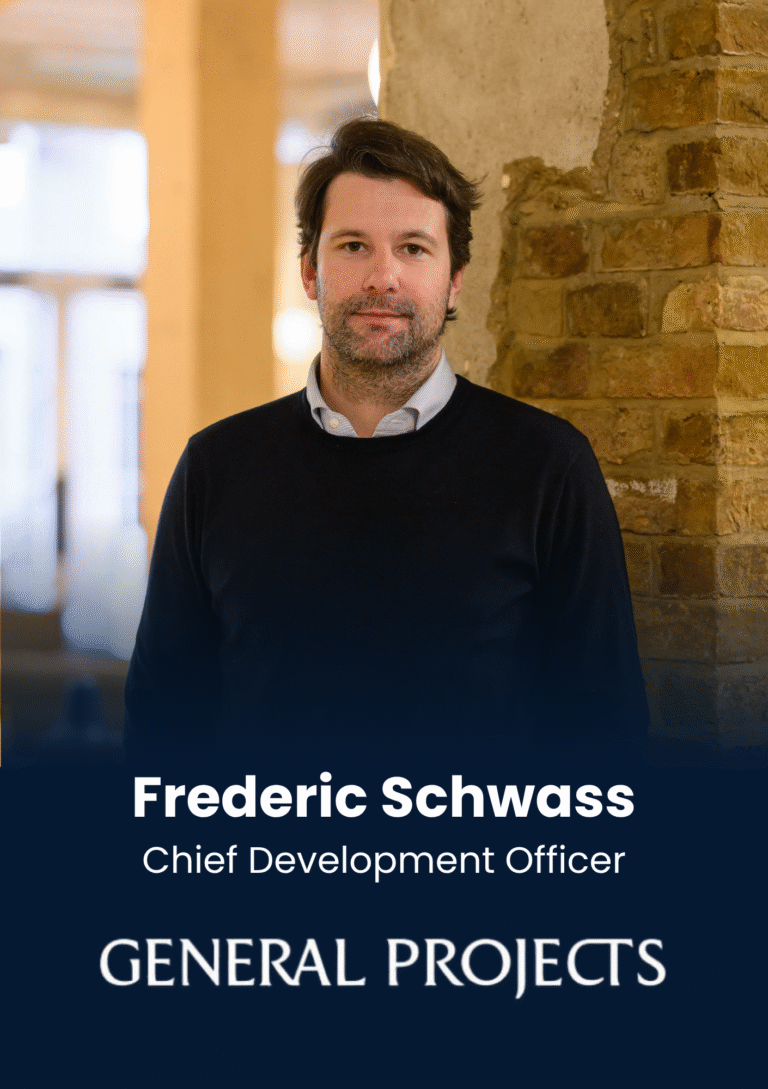 Portrait of Frederic Schwass, Chief Development Officer, standing against a brick wall in a warm office.