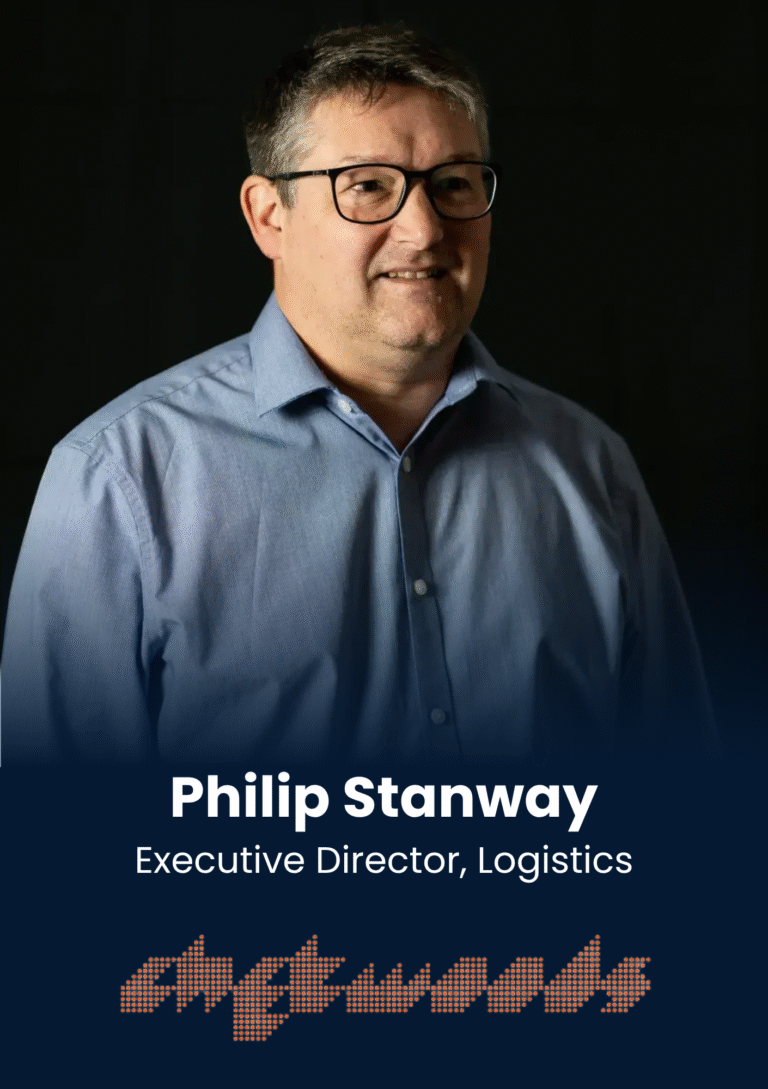 Portrait of a middle-aged man wearing glasses and a blue button-down shirt against a dark background, with a text overlay showing a name and role.