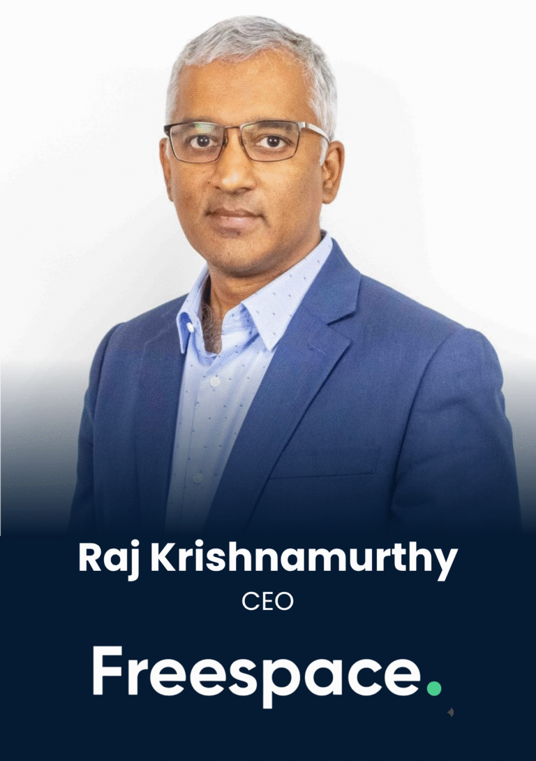Portrait of Raj Krishnamurthy, wearing a blue suit and glasses, against a white background (CEO of Freespace).