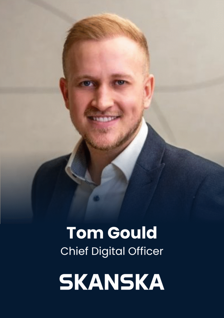 Portrait of Tom Gould, Chief Digital Officer at Skanska, smiling in a dark suit and white shirt