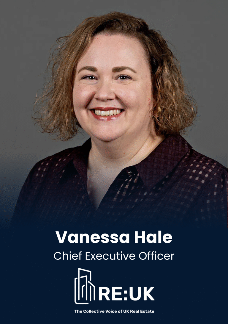 Smiling woman head-and-shoulders portrait in a dark checkered blouse; professional headshot with a blue gradient banner and RE:UK branding at the bottom.