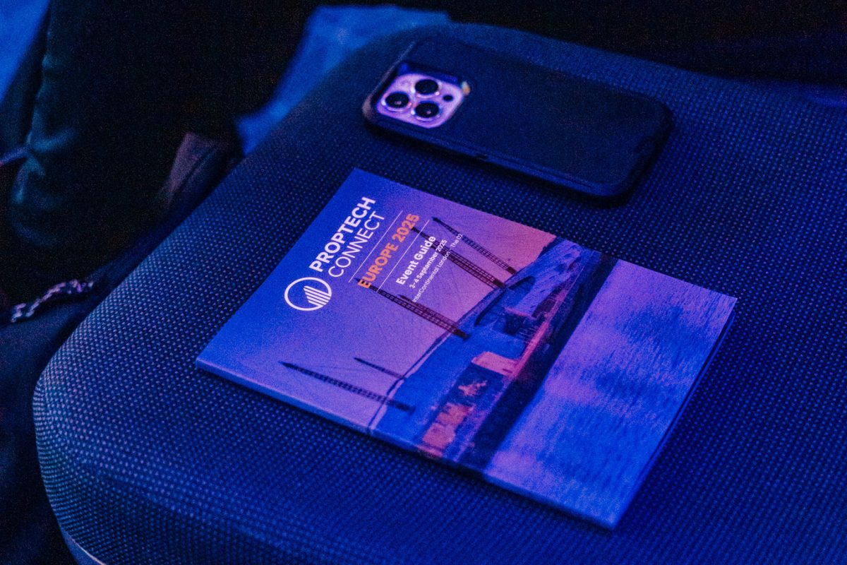 Smartphone resting on a blue brochure on a fabric car seat under blue lighting